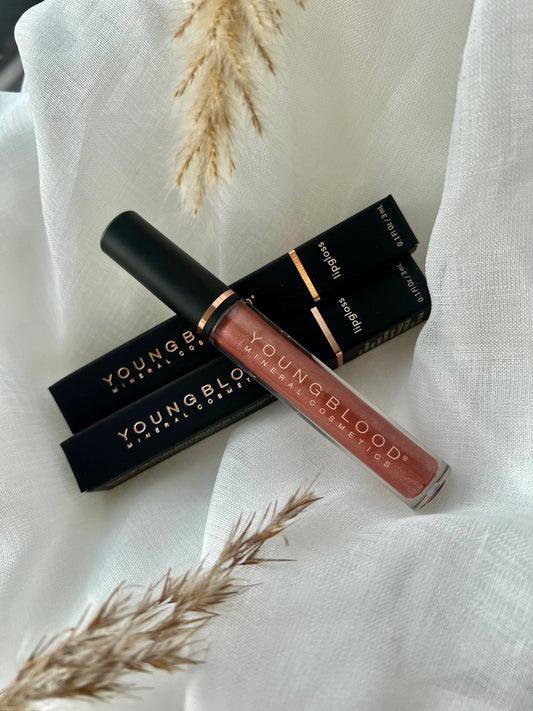 Young Blood Lipgloss i farven Poetic. Luksuriøs lipgloss med skinnende finish, der giver læberne et fyldigt og blødt udseende. Den drømmende Poetic-nuance skaber et sofistikeret og feminint udtryk med sit delikate farvespil. Produktet vises i Young Bloods elegante emballage, der afspejler mærkets høje kvalitet og naturlige ingredienser