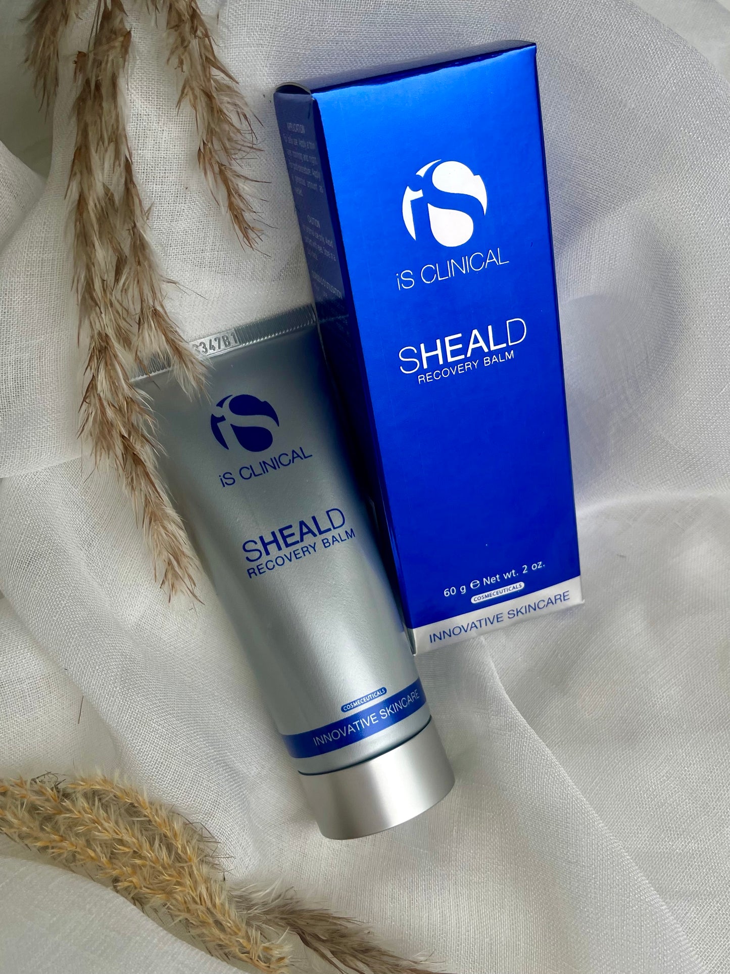 IS Clinical Sheald Recovery Balm helende og beskyttende hudbalm til skadet, irriteret og følsom hud, med antioxidanter og botaniske ekstrakter, fremmer hudens naturlige helingsproces, reducerer rødme og ubehag, ideel efter behandlinger og ved miljøstress.