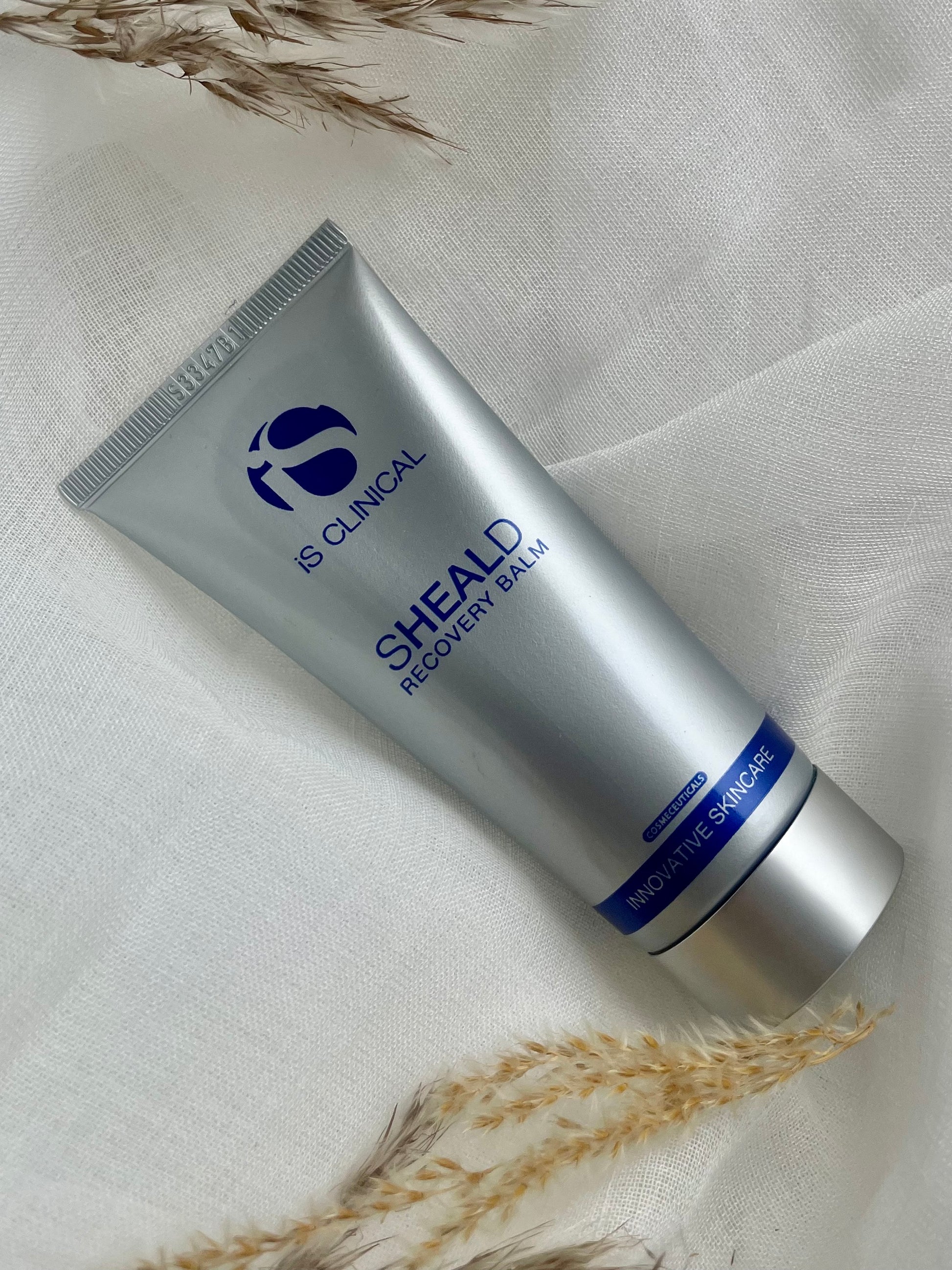 IS Clinical Sheald Recovery Balm helende og beskyttende hudbalm til skadet, irriteret og følsom hud, med antioxidanter og botaniske ekstrakter, fremmer hudens naturlige helingsproces, reducerer rødme og ubehag, ideel efter behandlinger og ved miljøstress.