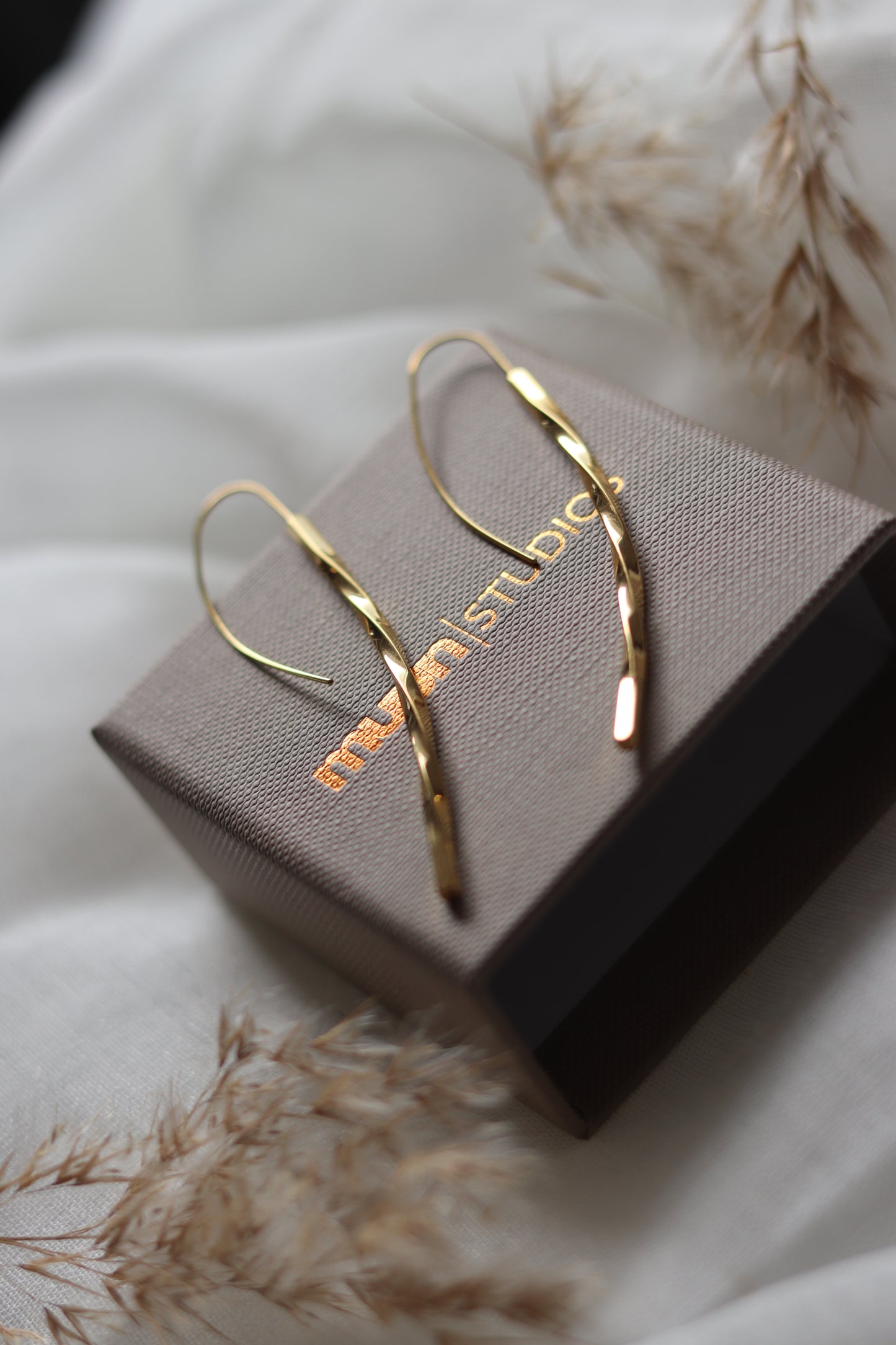 Guld øreringe, snoet på emballage