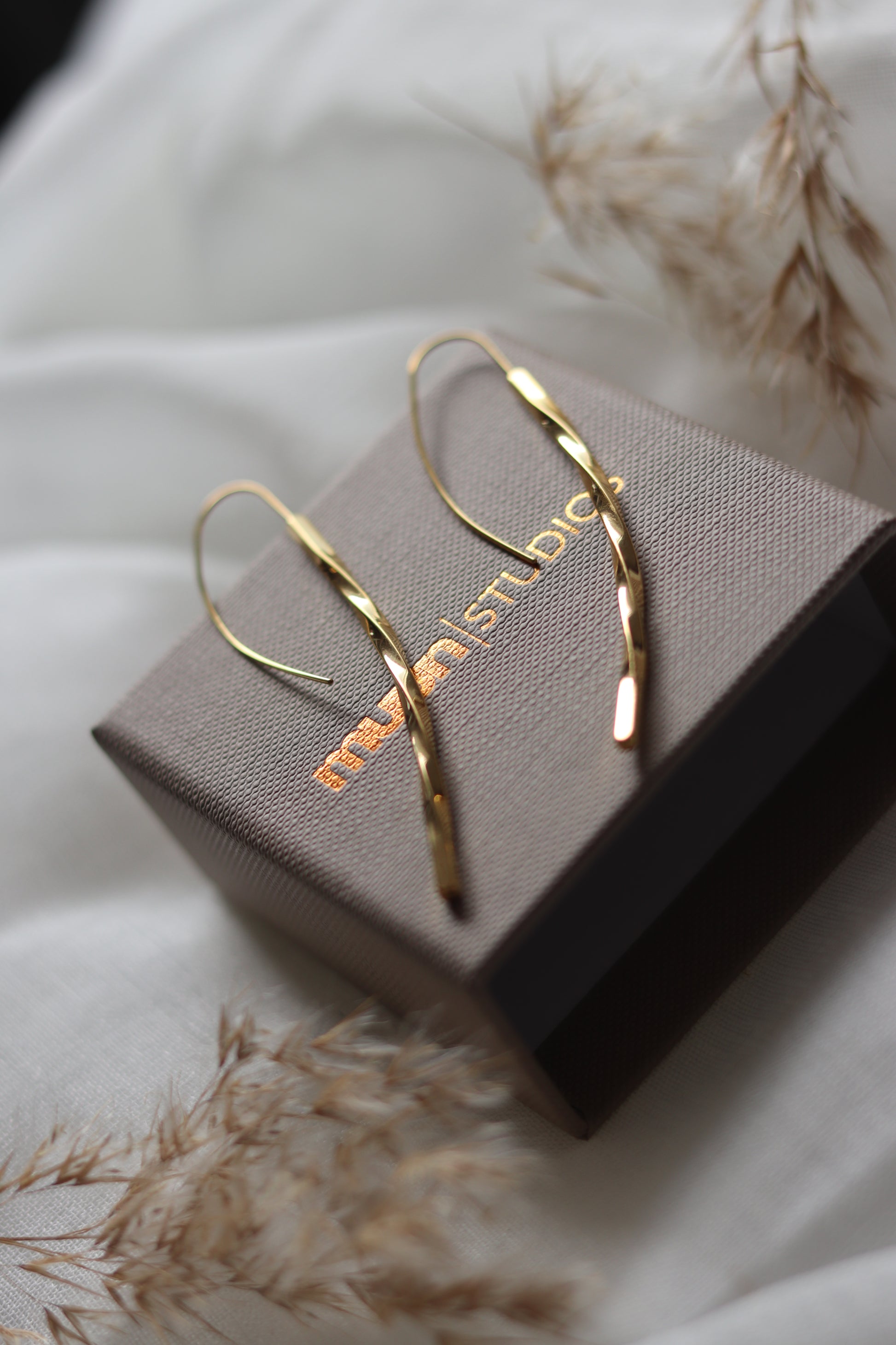 Guld øreringe, snoet på emballage